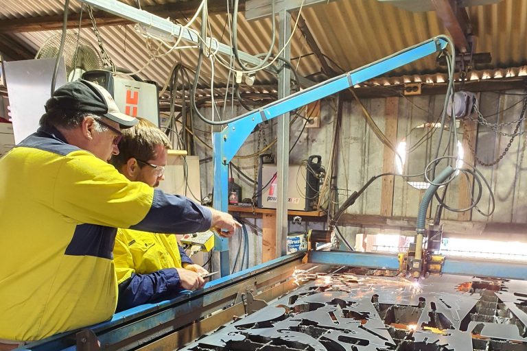 Two men working in a metal workshop