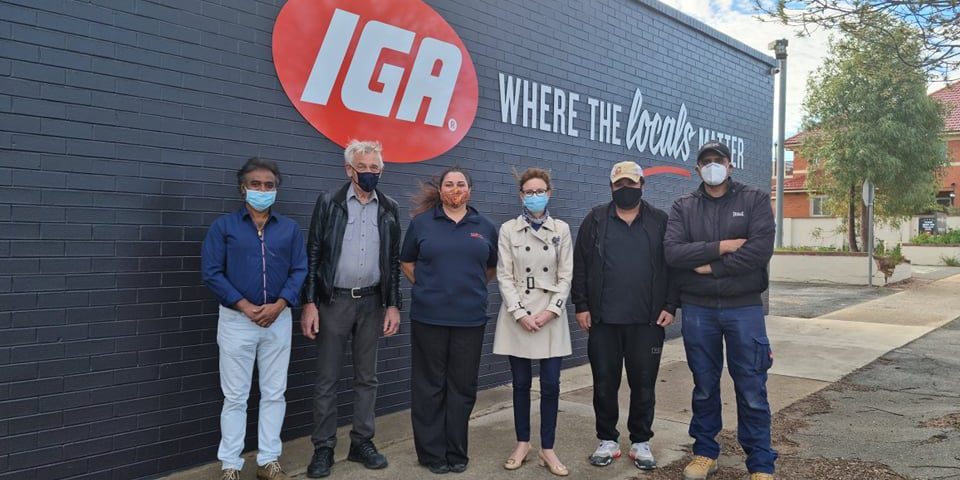 Six people stand outside the new IGA store in Narranderra